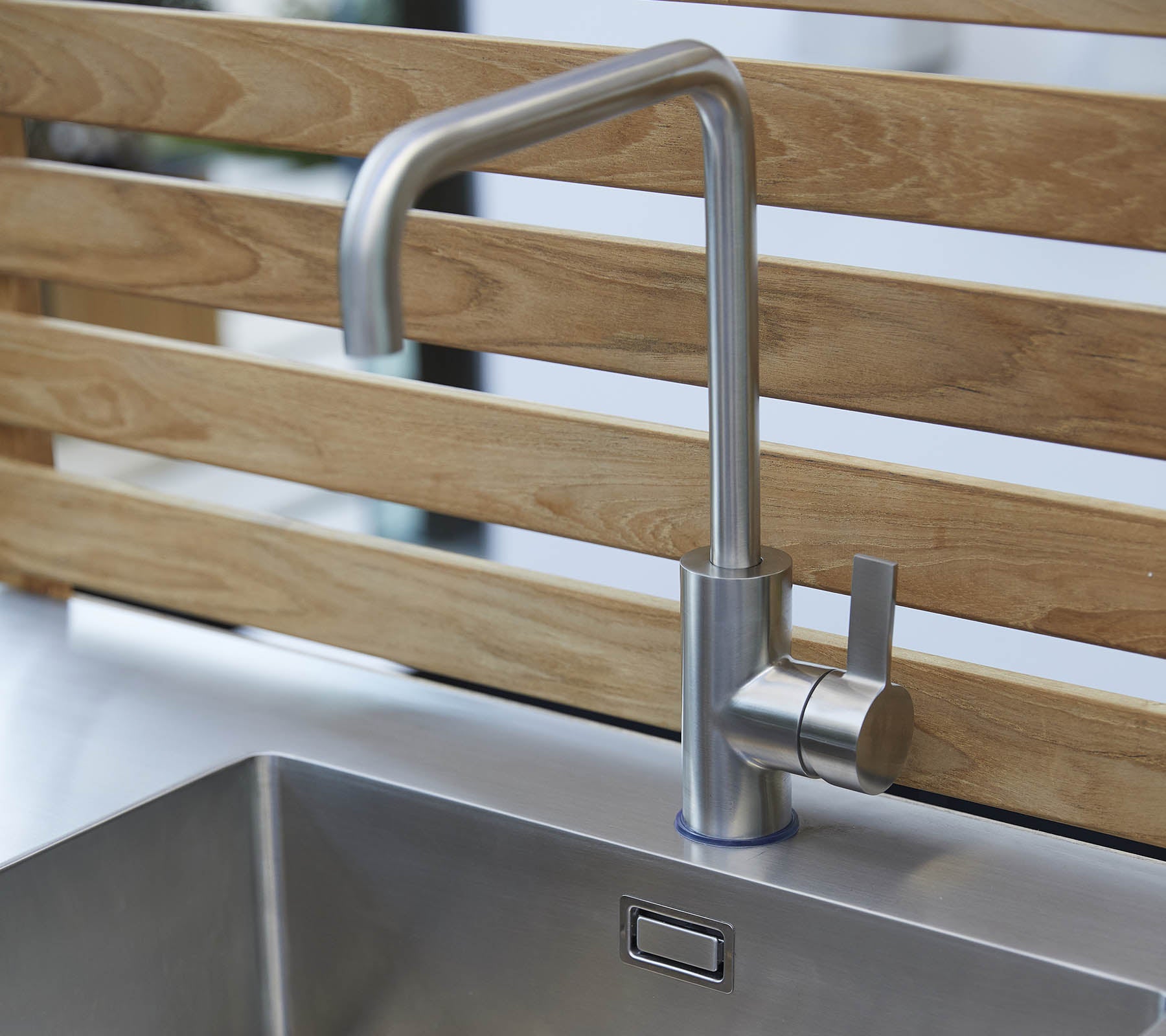 Stylish stainless steel faucet with a sleek design and a single lever control, positioned above a modern sink.