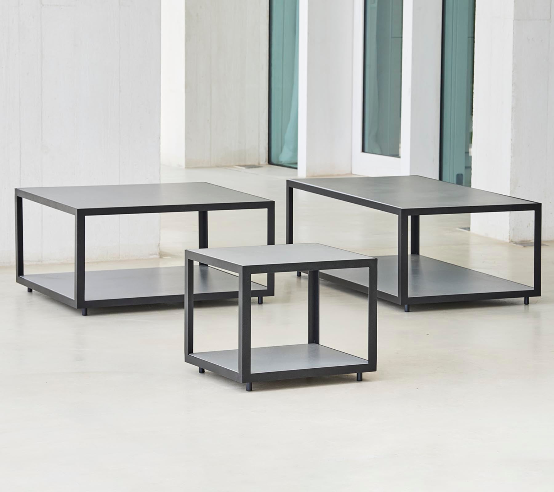 Three modern tables with a minimalist design, featuring a sleek frame and multiple tiers for storage or display.
