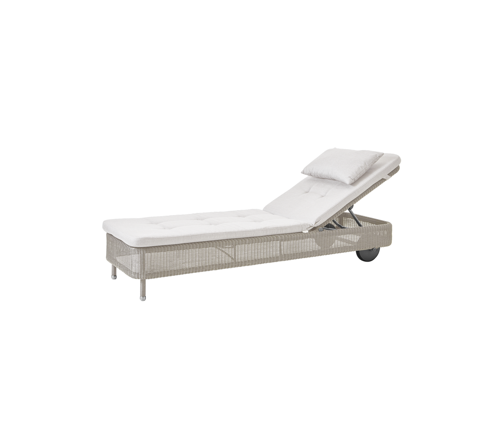 Modern sand lounger with a white cushion, suitable for outdoor relaxation.