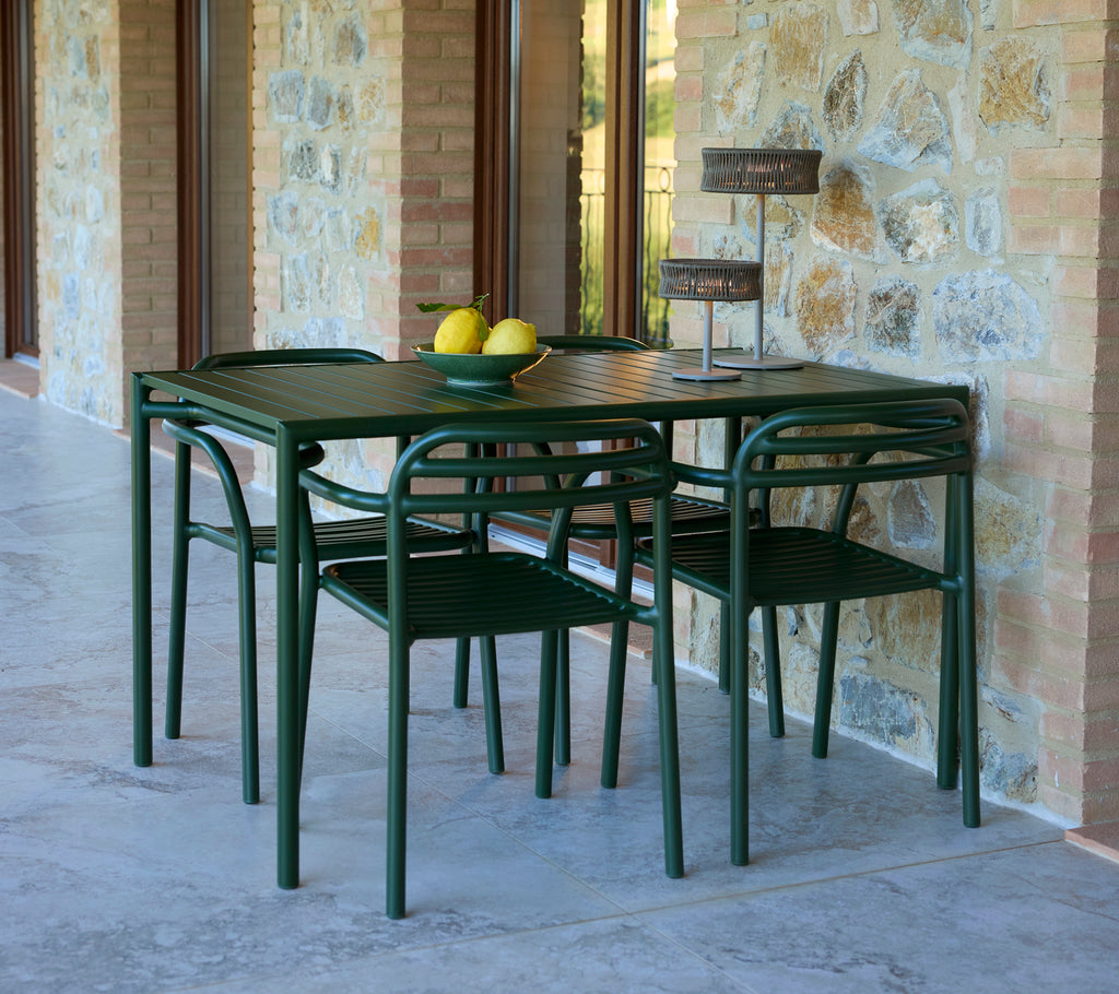 Bliss rectangular table with Bliss chairs and an Illusion lamp, featuring decorative lemons and a stylish stone backdrop.