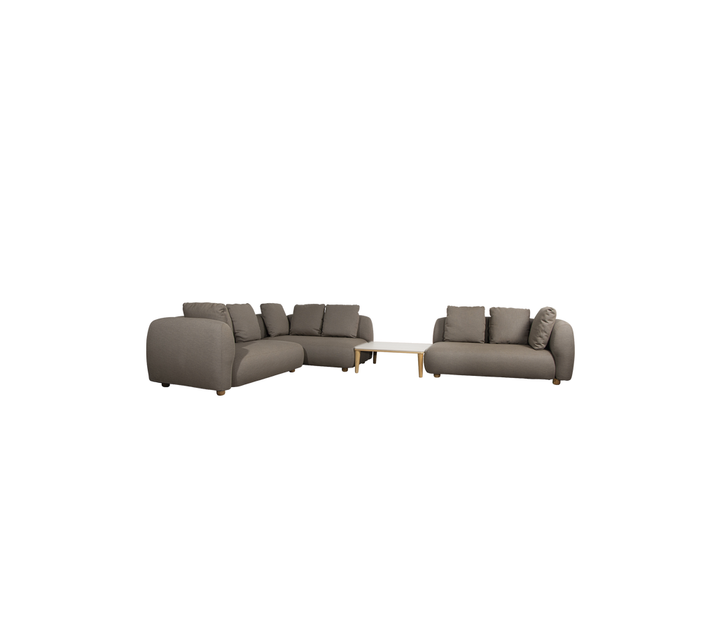 Modern taupe sofa with cushions and a light table in a lounge setting.