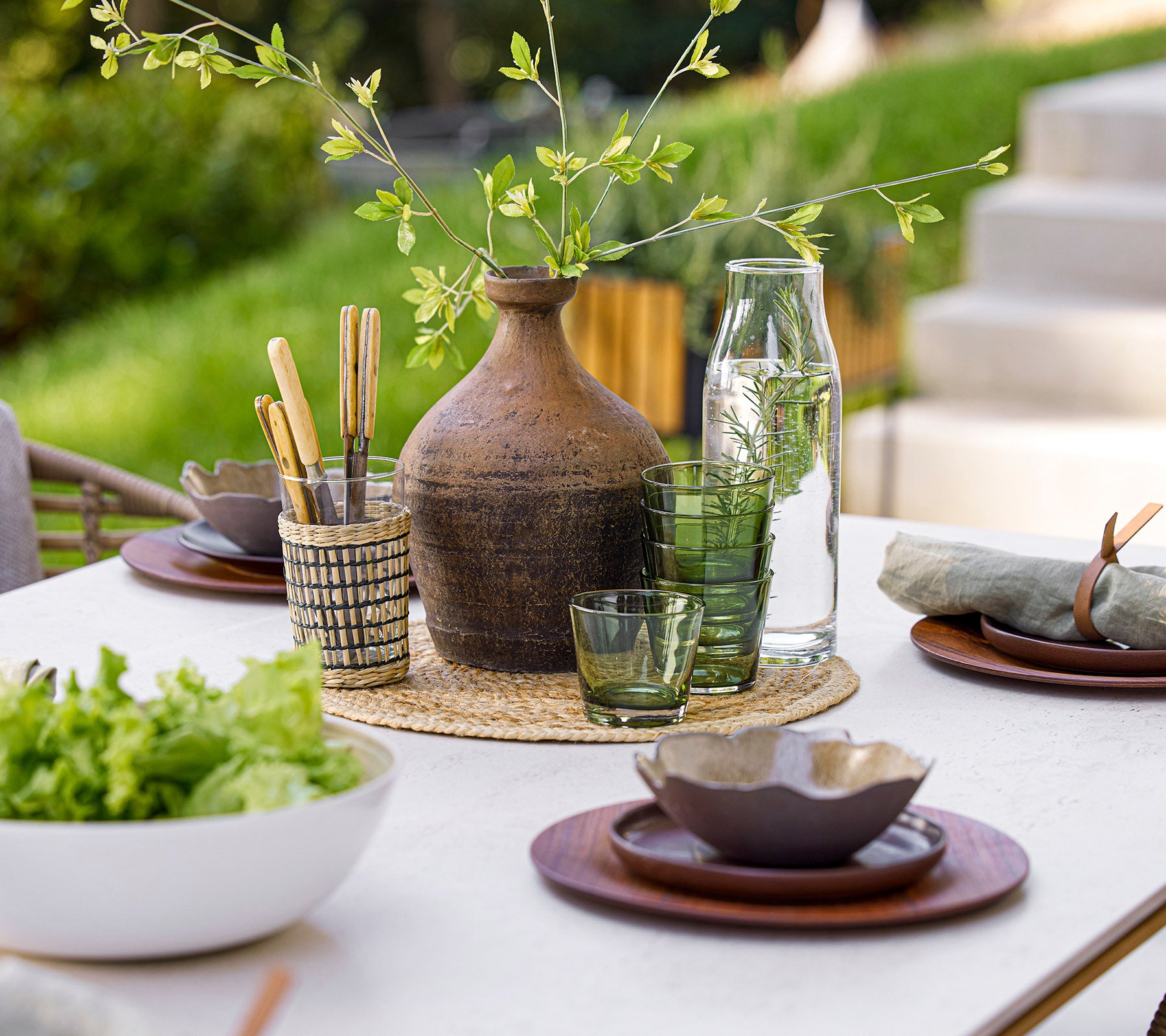 A beautifully arranged dining table featuring glassware, natural elements, and elegant tableware, creating a serene dining atmosphere.