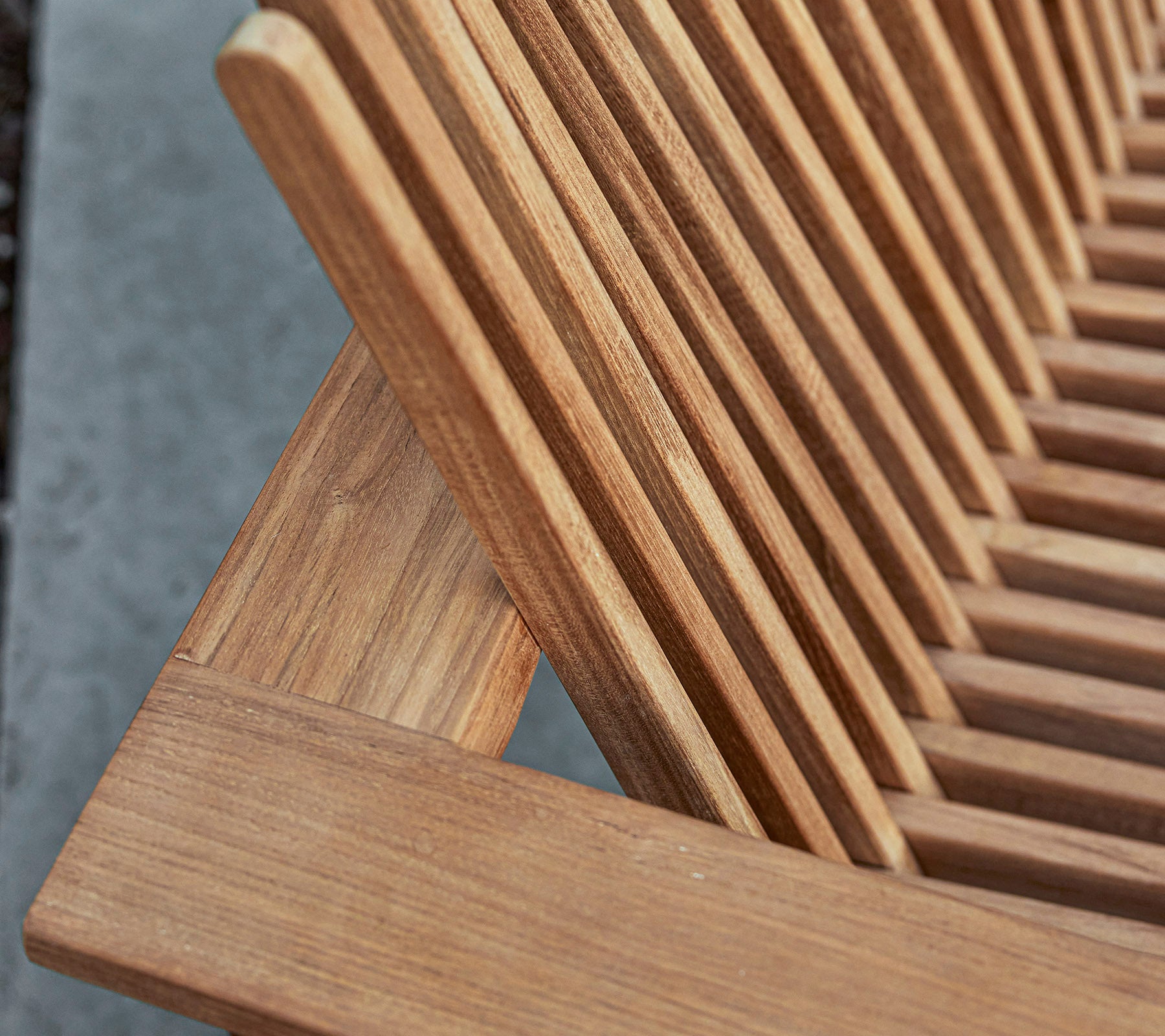 Close-up of a wooden furniture piece featuring slatted design, showcasing the natural grain and craftsmanship details.