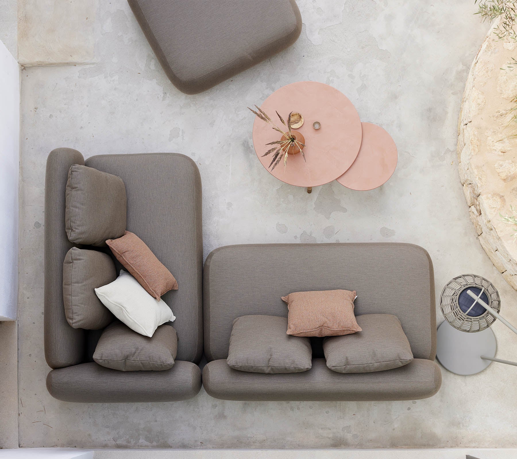 A stylish seating arrangement featuring a neutral-colored sofa with decorative pillows, accompanied by a unique twist coffee table.