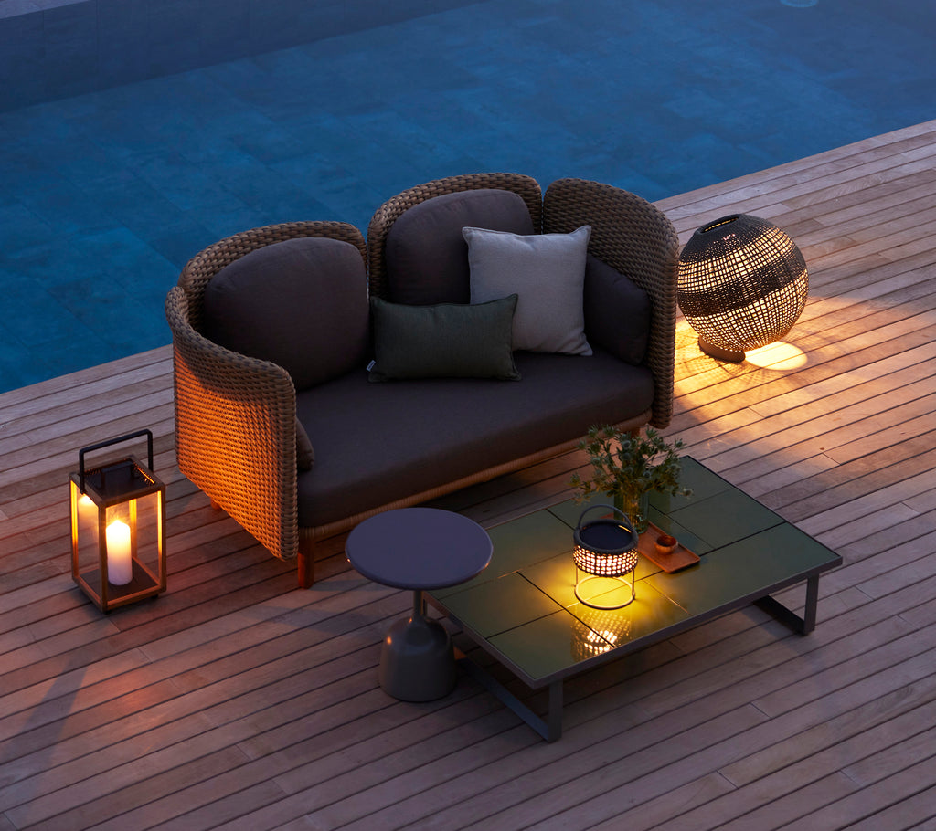 Cozy seating area featuring a round illusion lamp, a glaze coffee table, and decorative elements, creating a warm ambiance.
