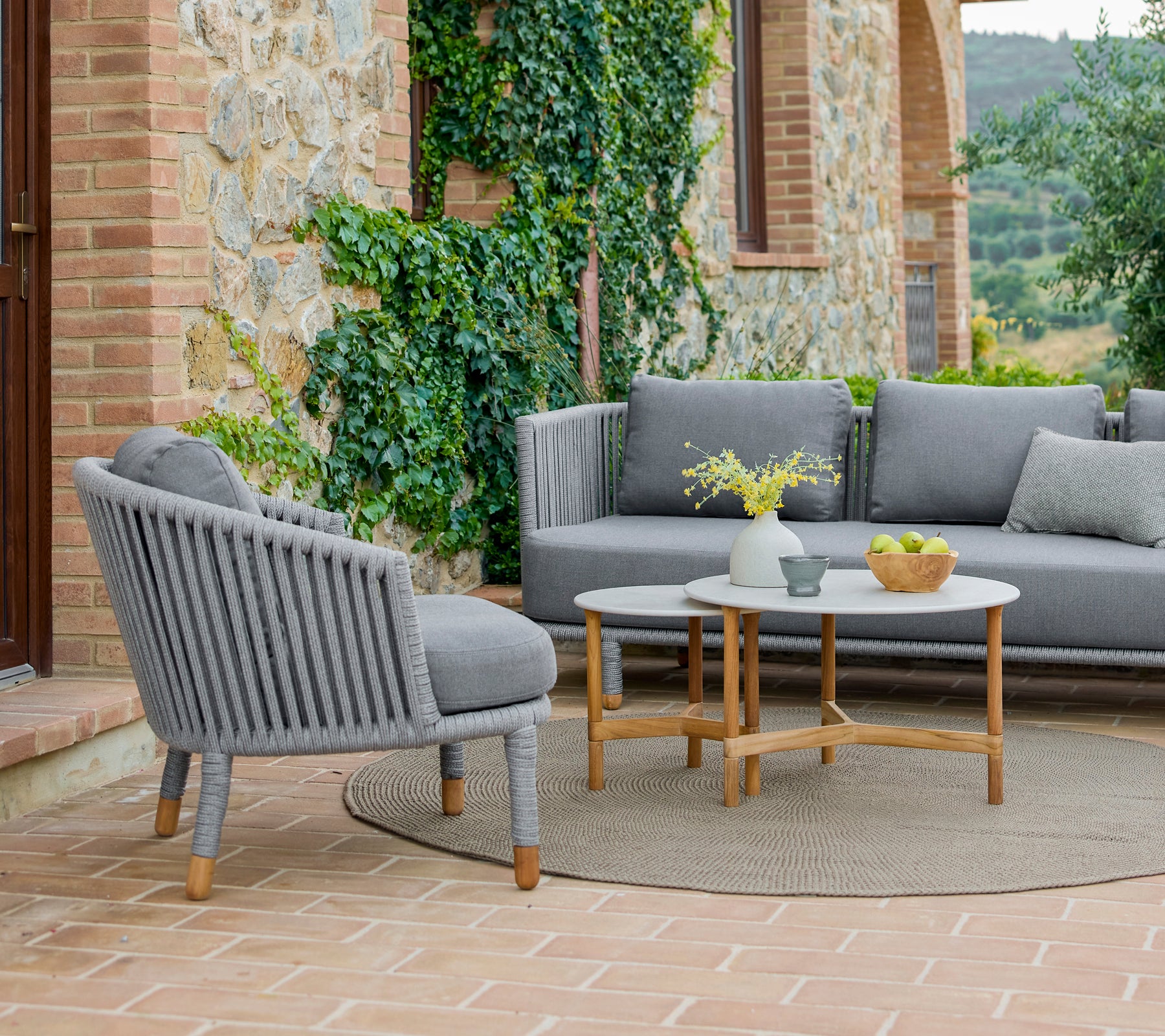 A stylish lounge chair and coffee table set featuring a modern design, surrounded by greenery and a warm, inviting atmosphere.
