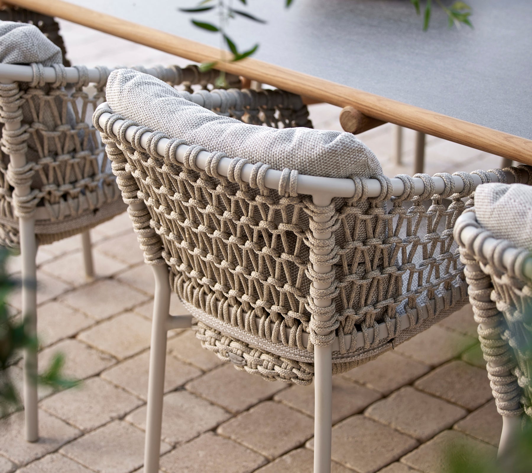 Cozy dining chairs with a woven design and soft cushions, perfect for stylish outdoor dining.