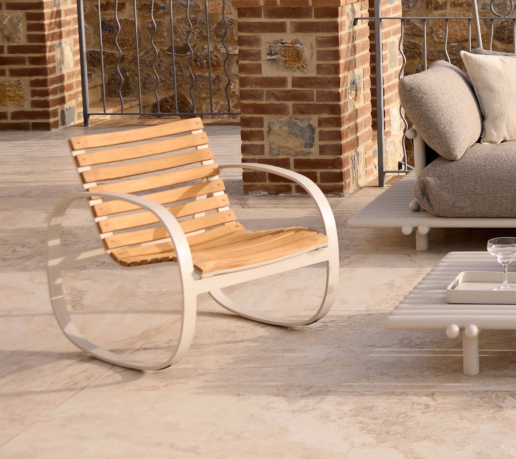 Stylish rocking chair featuring a sleek aluminum frame and wooden slats, perfect for relaxing in contemporary spaces.