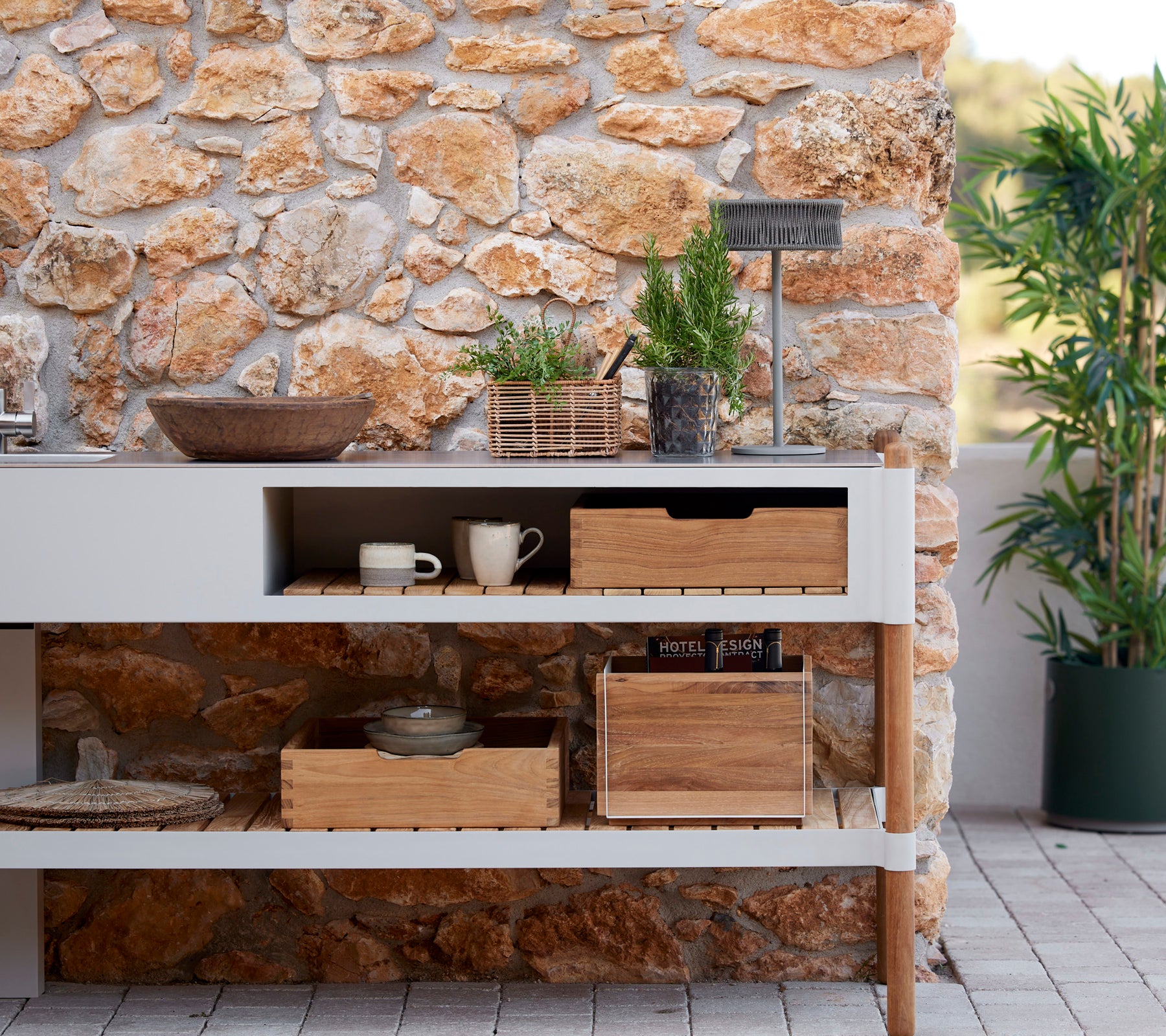 Stylish kitchen setup featuring a stone wall, wooden storage boxes, potted plants, and an illusion lamp for an inviting atmosphere.