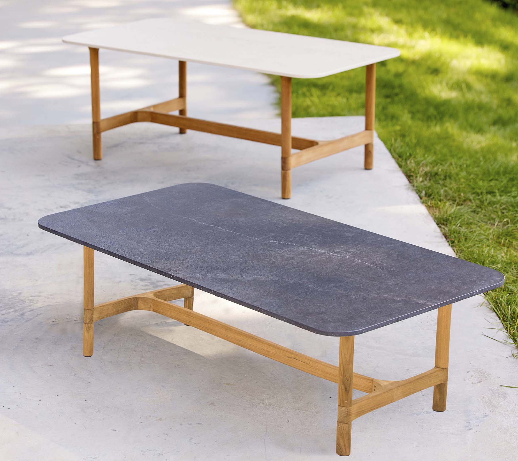 Two stylish coffee tables with wooden frames and contrasting tabletop colors, featuring a modern, minimalist design.